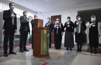 Members of an election commission listen to the national anthem at a polling station during the presidential election in Tashkent, Uzbekistan, Sunday, Oct. 24, 2021. Uzbekistan's President, Shavkat Mirziyoyev, who has relaxed many of the policies of his dictatorial predecessor but has made little effort at political reform, is expected to win a new term by a landslide against weak competition in an election Sunday. (AP Photo)