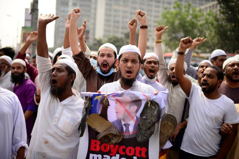 Supporters of Islamic Andolan Bangladesh, an Islamist political party, carry a poster of French President Emmanuel Macron with footwear around it as they protest against the publishing of caricatures of the Prophet Muhammad they deem blasphemous, in Dhaka, Bangladesh, Oct. 27, 2020.