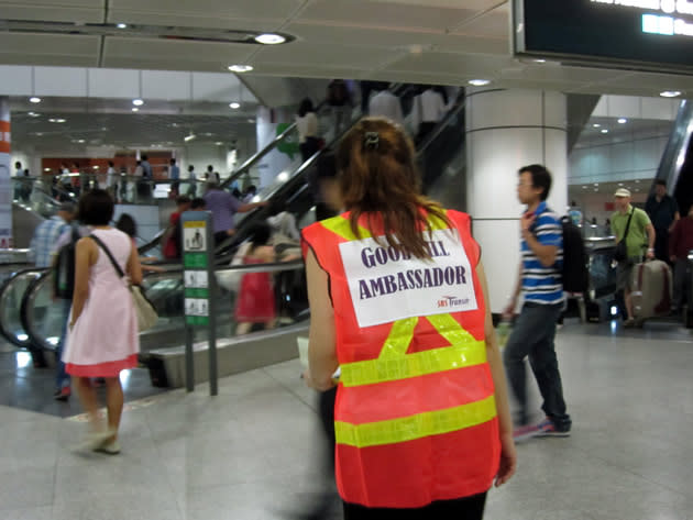 An SBS Transit "goodwill ambassador" helping a commuter with directions to her destination. (Yahoo! photo/Jeanette Tan)