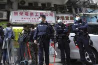 Police officers stand guard outside office of District councillor and lawyer Daniel Wong Kwok-tung, while police search in Hong Kong, Thursday, Jan. 14, 2021. Wong, a member of the city's Democratic Party, is known for providing legal assistance to hundreds of protesters arrested during the anti-government protests in Hong Kong in 2019. Hong Kong national security police on Thursday arrested a lawyer and 10 others on suspicion of helping 12 Hong Kongers try to flee the city, local media reported in the latest arrests in an ongoing crackdown on dissent. (AP Photo/Vincent Yu)