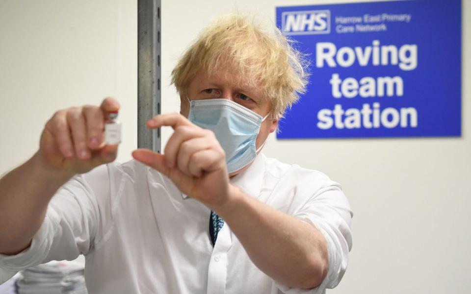 Johnson holds a vial of the Oxford/Astrazeneca coronavirus vaccine during a visit to a vaccination centre - Stefan Rousseau