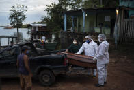 SOS Funeral workers move a coffin holding the body of an 86-year-old woman who lived by the Negro River and who is suspected of dying of COVID-19, near Manaus, Brazil, Thursday, May 14, 2020. The virus has spread upriver from Manaus, creeping into remote riverside towns and indigenous territories to infect indigenous tribes. (AP Photo/Felipe Dana)