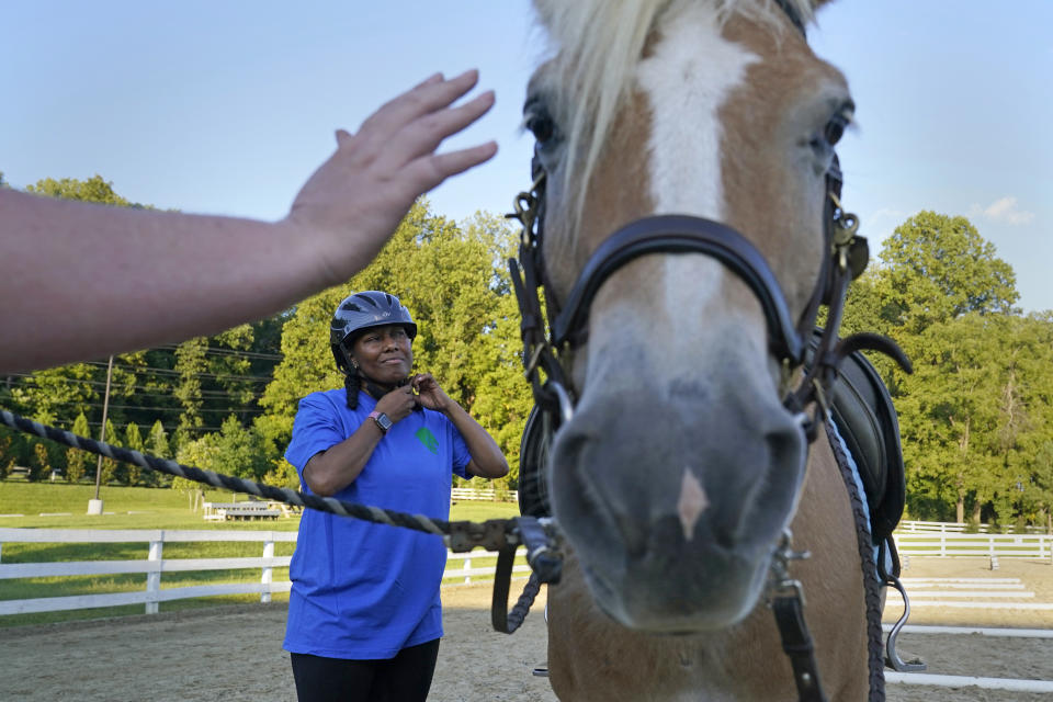 Dionne Williamson, of Patuxent River, Md., prepares for her riding lesson on Woody at Cloverleaf Equine Center in Clifton, Va., Tuesday, Sept. 13, 2022. After finishing a tour in Afghanistan in 2013, Williamson felt emotionally numb. She eventually found stability through a monthlong hospitalization and a therapeutic program that incorporates horseback riding. But she had to fight for years to get the help she needed. “It's a wonder how I made it through,” she said. (AP Photo/Susan Walsh)