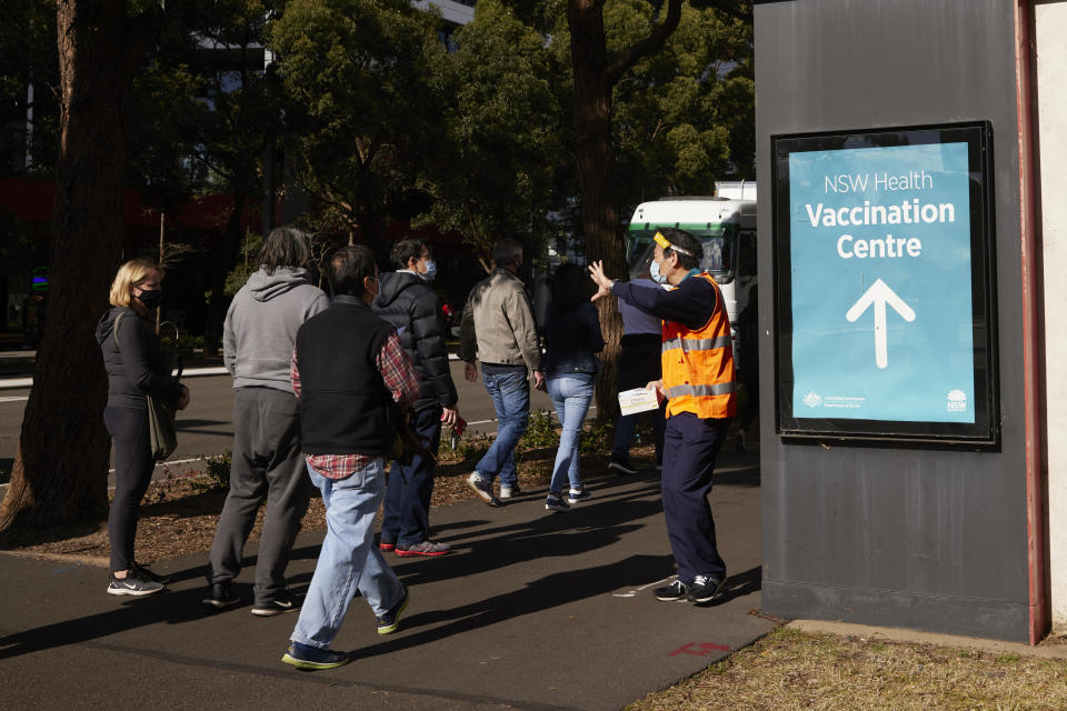 SYDNEY, AUSTRALIA - JULY 15: People queue up at the New South Wales Health mass vaccination hub in Homebush on July 15, 2021 in Sydney, Australia. Lockdown restrictions have been extended for at least a further two weeks as NSW continues to record new community COVID-19 cases. Residents of Greater Sydney, the Blue Mountains, the Central Coast and Wollongong are subject to stay-at-home orders with people are only permitted to leave their homes for essential reasons. Essential reasons include purchasing essential goods, accessing or providing care or healthcare, essential work, education or exercise. Exercise is restricted to within the local government area and no further than 10km from home and with a maximum of two people per group. Browsing in shops is prohibited and only one person per household can leave home for shopping per day. Outdoor public gatherings are limited to two people, while funerals are limited to 10 people only. The restrictions are expected to remain in place until 11:59pm on Friday 30 July. (Photo by Brook Mitchell/Getty Images)