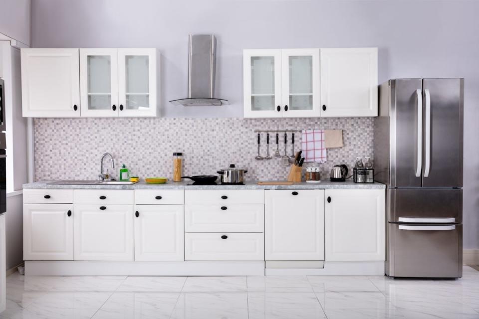 White and lilac kitchen with large open area above the top cabinets.