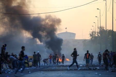 Demonstrators gather at a protest during a curfew, three days after the nationwide anti-government protests turned violent, in Baghdad