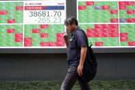 A person walks in front of an electronic stock board showing Japan's Nikkei 225 index at a securities firm Wednesday, May 22, 2024, in Tokyo. (AP Photo/Eugene Hoshiko)