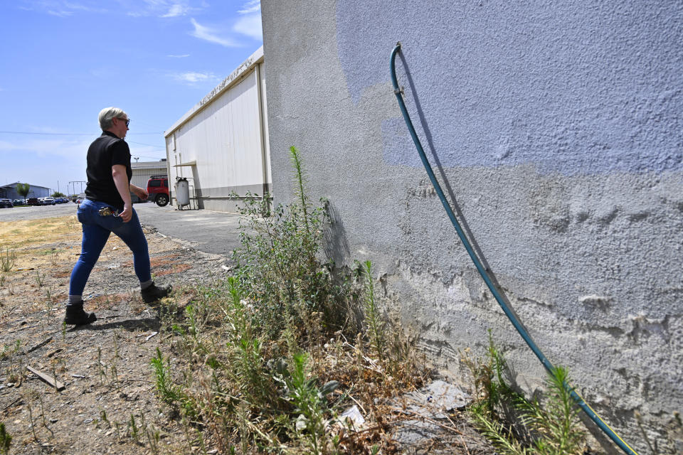 FILE - Code enforcement officer Jesalyn Harper walks past the garden hose which tipped her off to an illegal medical lab owned by Chinese business people that was operating inside an old warehouse in Reedley, Calif., on Aug. 1, 2023. Bei Zhu, 62, the Chinese owner of an unauthorized central California lab that fueled conspiracy theories about China and biological weapons was, Thursday, Oct. 19, 2023, arrested on charges of not obtaining the proper permits to manufacture tests for COVID-19, pregnancy and HIV, and mislabeling some of the kits. (Eric Paul Zamora/The Fresno Bee via AP, File)