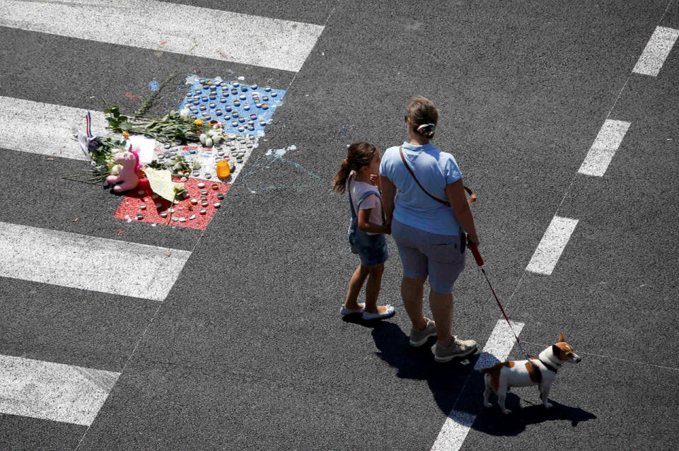 A woman and a child stand near a makeshift memorial