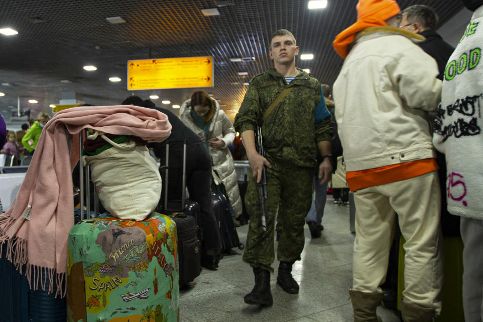 A Russian peacekeeper, center, patrols a hall where Russian citizens wait to board aircrafts of the Russian Aerospace Forces to leave Kazakhstan for Moscow at an airport in Almaty, Kazakhstan, Sunday, Jan. 9, 2022. The first three aircraft of the Aerospace Forces with the Russians flew from Kazakhstan to Moscow. Three aircraft of the Russian Aerospace Forces flew from Kazakhstan to Moscow together with the Russians who wished to evacuate. TASS was informed about this by a representative of the Russian peacekeepers. (AP Photo/Vasily Krestyaninov)