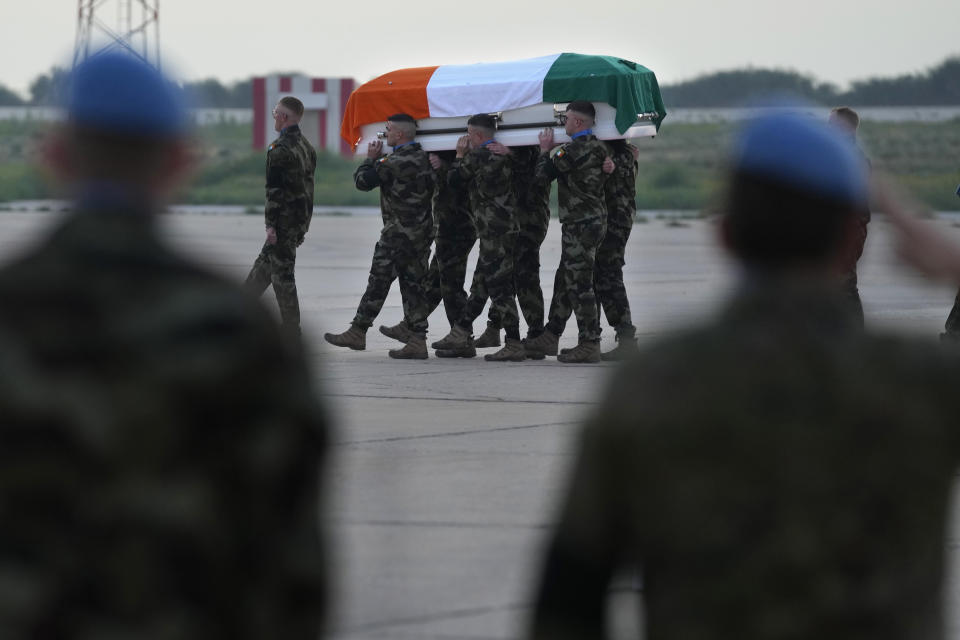 Irish U.N. peacekeepers, carry the coffin draped by their country flag of their comrade Pvt. Seán Rooney who was killed during a confrontation with residents near the southern town of Al-Aqbiya on Wednesday night, during his memorial procession at the Lebanese army airbase, at Beirut airport, Sunday, Dec. 18, 2022. (AP Photo/Hussein Malla)