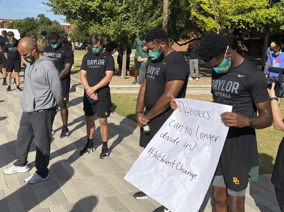 Members of the Baylor football team including Dave Aranda, bow their heads during a prayer after marching around campus, Thursday, Aug. 27, 2020, in Waco, Texas, protesting the shooting of Jacob Blake in Wisconsin. (Rod Aydelotte/Waco Tribune-Herald via AP)