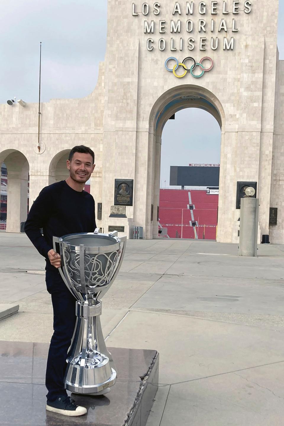 Kyle Larson poses with the NASCAR Cup Series championship trophy in front of the Los Angeles Memorial Coliseum on Nov. 9, 2021, two days after winning the title at Phoenix Raceway. NASCAR starts the 2022 season in the Busch Clash at the Coliseum on Feb. 6.