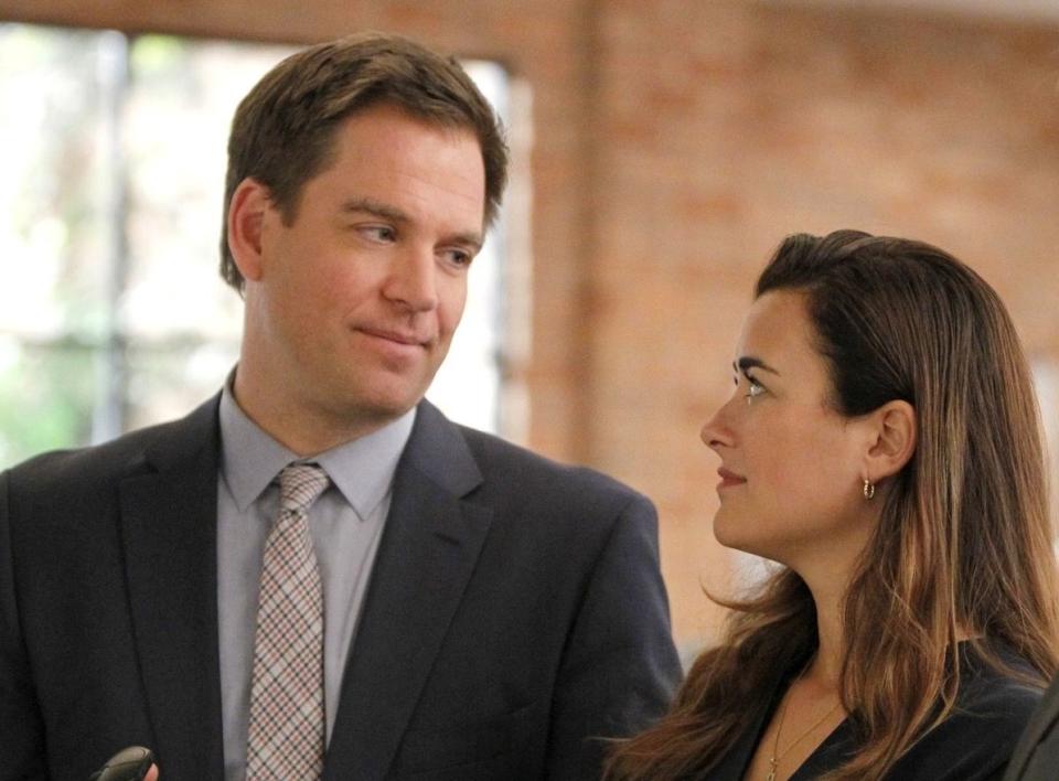 Dinozzo and Ziva in NCIS, standing close and sharing a smirk in an indoor setting