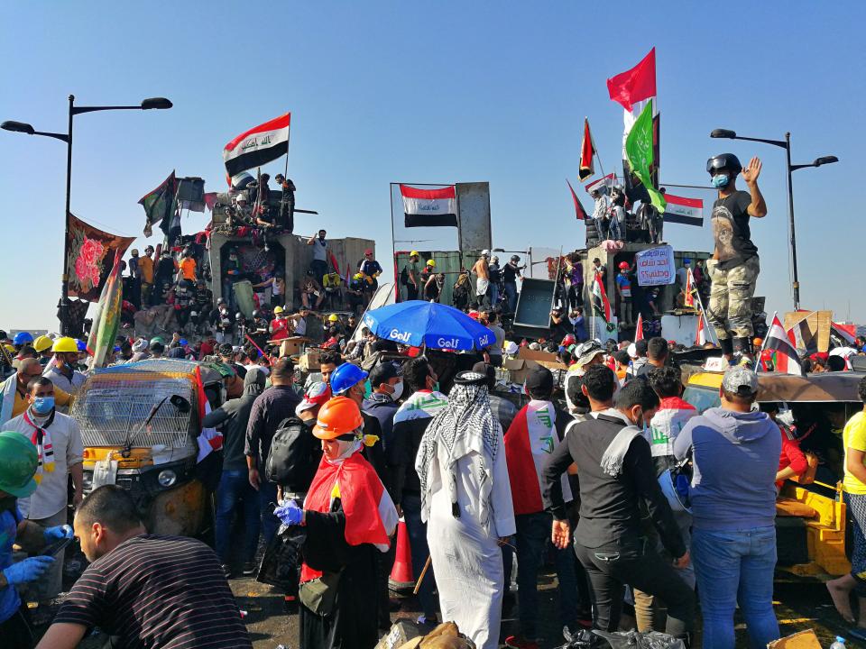 Anti-government protesters control some barriers set by Iraqi security forces to close the bridge leading to the Green Zone during ongoing protests in Baghdad, Iraq, Friday, Nov. 1, 2019. (AP Photo/Khalid Mohammed)