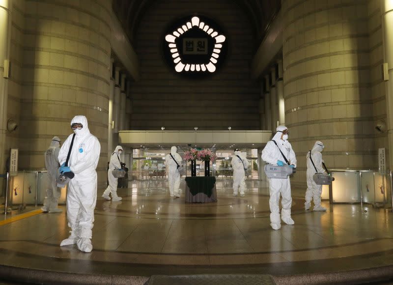 Quarantine workers spray disinfectant at the Seoul district court building, following the coronavirus disease (COVID-19) outbreak, in Seoul