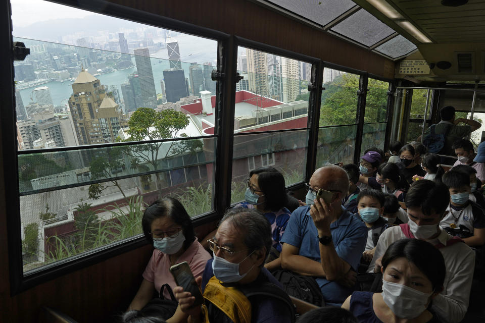 Passengers enjoy a view from the cabin as a Peak Tram goes downhill of the Victoria Peak in Hong Kong on June 17, 2021. Hong Kong’s Peak Tram is a fixture in the memories of many residents and tourists, ferrying passengers up Victoria Peak for a bird’s eye view of the city’s many skyscrapers. (AP Photo/Vincent Yu)