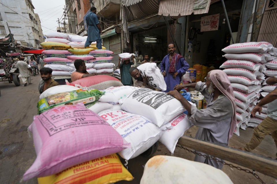 Laborers load sacks of lentils onto a donkey cart at a wholesale market in Karachi, Pakistan, Thursday, July 13, 2023. Pakistan's finance minister said the International Monetary Fund deposited a much-awaited first installment of $1.2 billion with the country's central bank under a recently signed bailout aimed at enabling the impoverished Islamic nation to avoid defaulting on its debt repayments. The IMF said its executive board had approved an agreement to release a $3 billion loan to support Pakistan's economic stabilization program. (AP Photo/Fareed Khan)