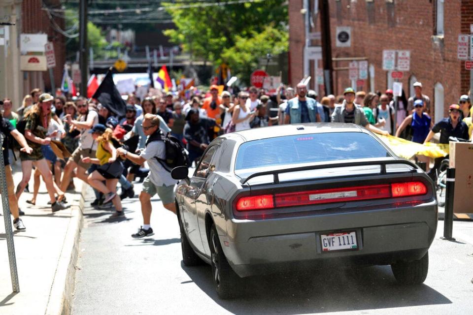 In this Aug. 12, 2017 file photo, a vehicle drives into a group of protesters demonstrating against a white nationalist rally in Charlottesville, Va.  A federal judge on Wednesday, May 5, 2021,  has ordered a right-wing think tank led by white nationalist Richard Spencer to pay $2.4 million to an Ohio man severely injured during a white supremacist and neo-Nazi rally two years ago in Virginia organized by Spencer.  Bill Burke says he was struck by a car driven by James Alex Fields Jr. , in a crash that killed counterprotester Heather Heyer, during the August 2017 rally in Charlottesville.