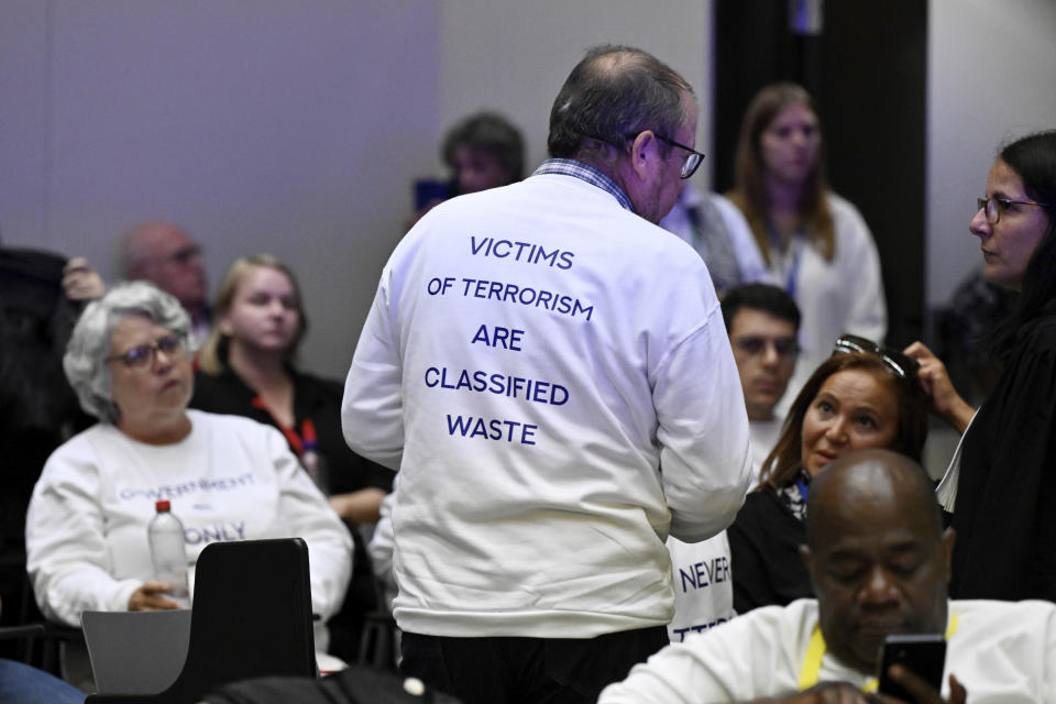 A member of the United Organisation of Victims, center, speaks with lawyer Delphine Paci in the courtroom prior to the reading of the sentences during the trial regarding the attacks at a Brussels metro station and the city's airport at the Justitia building in Brussels, Friday, Sept. 15, 2023. The morning rush hour attacks at Belgium's main airport and on the central commuter line took place on March 22, 2016, which killed 32 people, and nearly 900 others were wounded or suffered mental trauma. (John Thys, Pool Photo via AP)