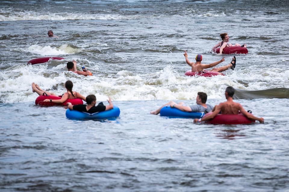 Cyclists cool off while floating down the whitewater course on the Cedar River in Charles City during RAGBRAI in 2022.