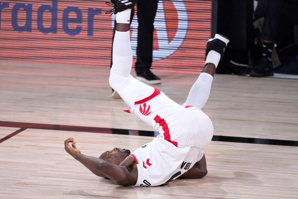 Toronto Raptors' Serge Ibaka (9) falls back after being fouled by the Boston Celtics during the first half of an NBA conference semifinal playoff basketball game Friday, Sept. 11, 2020, in Lake Buena Vista, Fla. (AP Photo/Mark J. Terrill)