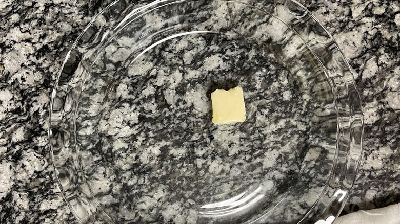 pat of butter in glass pie dish