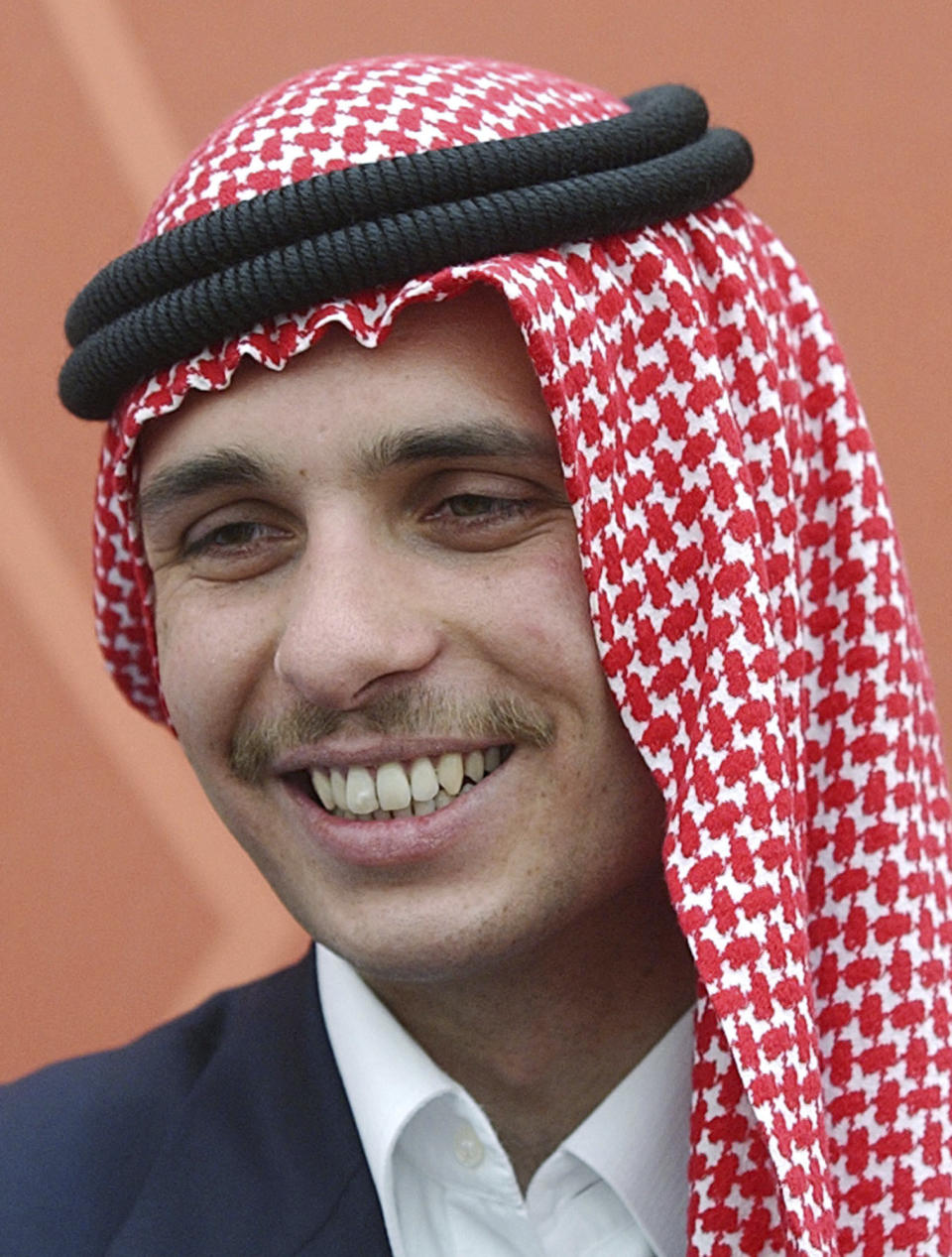 FILE - Jordan's then Crown Prince Hamzah smiles during a royal lunch hosted for tribesmen at the Royal Palace compound in Amman, Jordan, May 26, 2004. Prince Hamzeh, the half-brother of Jordan’s king, posted a letter on his official Twitter account on Sunday, April 3, 2022, relinquishing his princely title, a year after a rare palace feud saw him placed under house arrest. (AP Photo/Hussein Malla, File)