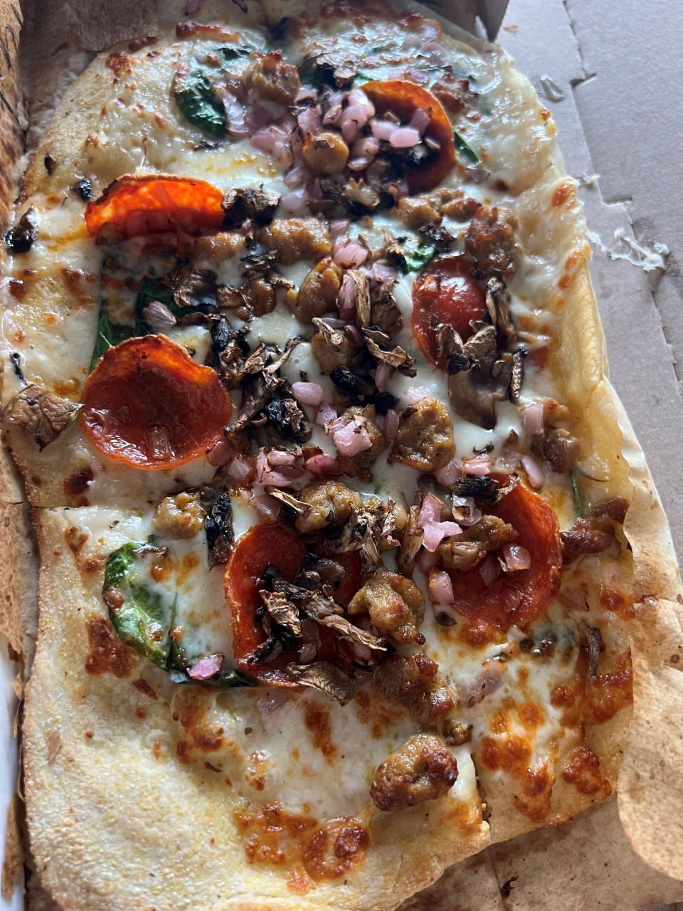 Slim & Husky's PREAM pizza at its North Nashville location on Nov. 7, 2022, has white sauce, sausage, pepperoni, spinach, mushrooms and red onion