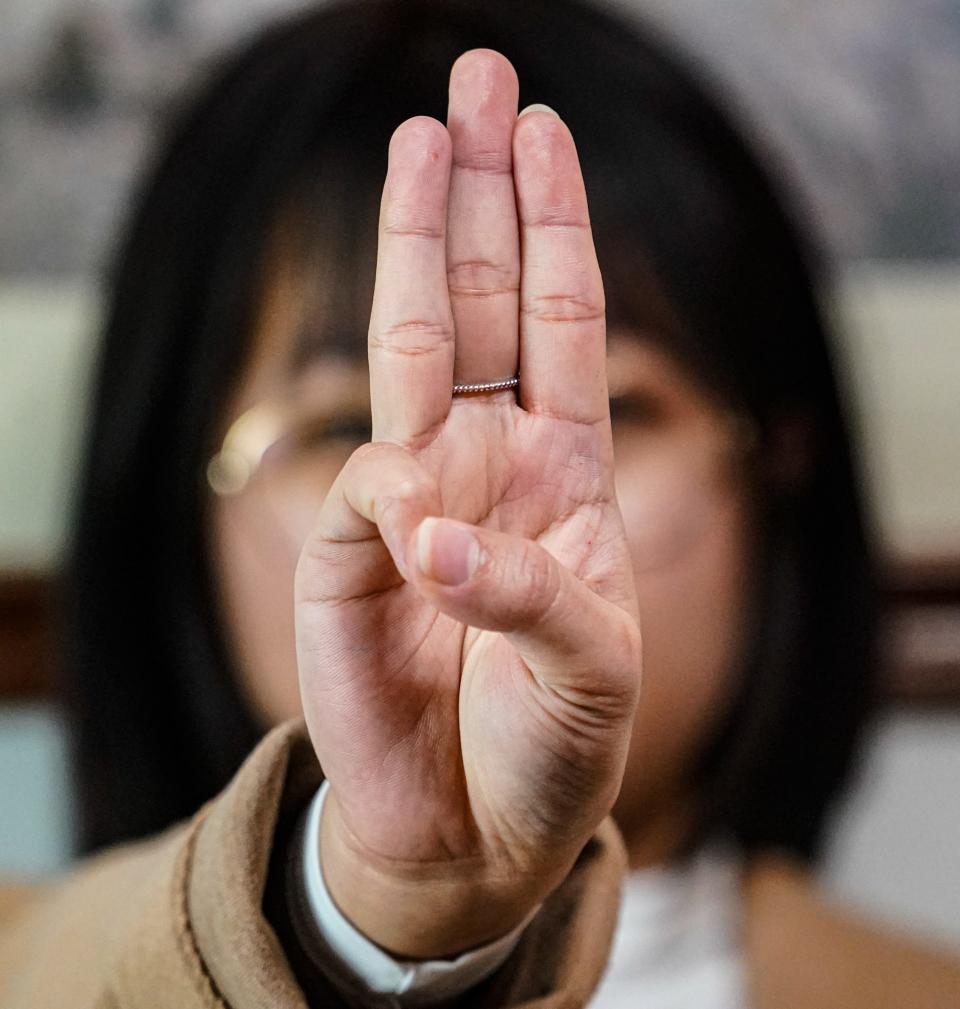 Ngun Tha Par, a Burmese refugee who came to the U.S. after the military seized control of the democratically elected Myanmar government in 2021, flashes a three-fingered salute. The gesture, which originated in the "Hunger Games" films, has been adopted by freedom fighters in her home country.