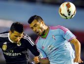 Celta Vigo's Gustavo Cabral (R) fights for the ball with Real Madrid's Cristiano Ronaldo during their Spanish first division soccer match at Balaidos stadium in Vigo April 26, 2015. REUTERS/Miguel Vidal