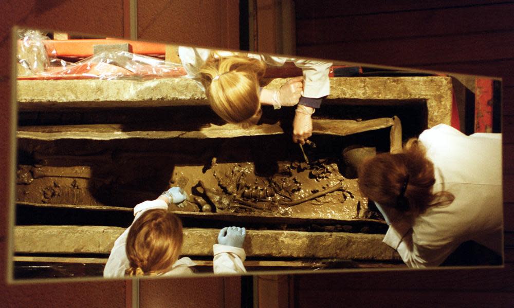 Archaelogists inspect a skeleton