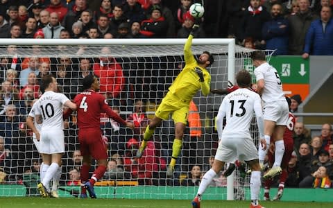 Liverpool's Brazilian goalkeeper Alisson Becker (C) punches the ball away during the English Premier League football match between Liverpool and Burnley at Anfield in Liverpool, north west England on March 10, 2019. (Photo by Paul ELLIS / AFP) / RESTRICTED TO EDITORIAL USE. No use with unauthorized audio, video, data, fixture lists, club/league logos or 'live' services. Online in-match use limited to 120 images. An additional 40 images may be used in extra time. No video emulation. Social media in-match use limited to 120 images. An additional 40 images may be used in extra time. No use in betting publications, games or single club/league/player publications