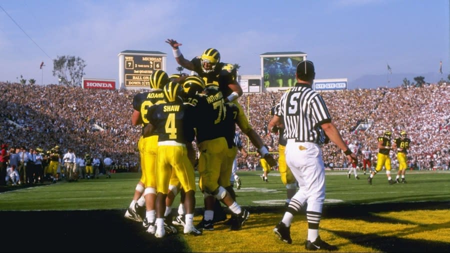 Brian Griese leaps on top of a group of teammates in the end zone.