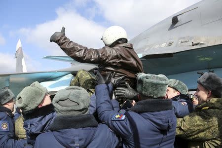 A Russian military pilot is greeted upon his return from Syria to a home airbase during a welcoming ceremony in Buturlinovka in Voronezh region, Russia March 15, 2016. REUTERS/Russian Ministry of Defence/Olga Balashova/Handout via Reuters