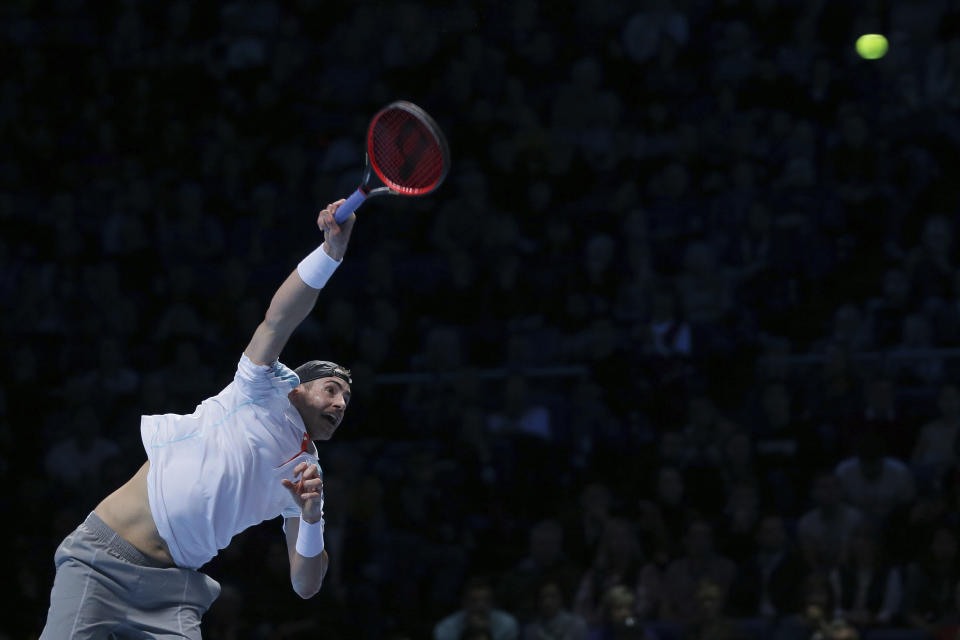 John Isner of the United States serves to Novak Djokovic of Serbia in their ATP World Tour Finals tennis match at the O2 Arena in London, Monday Nov. 12, 2018. (AP Photo/Tim Ireland)