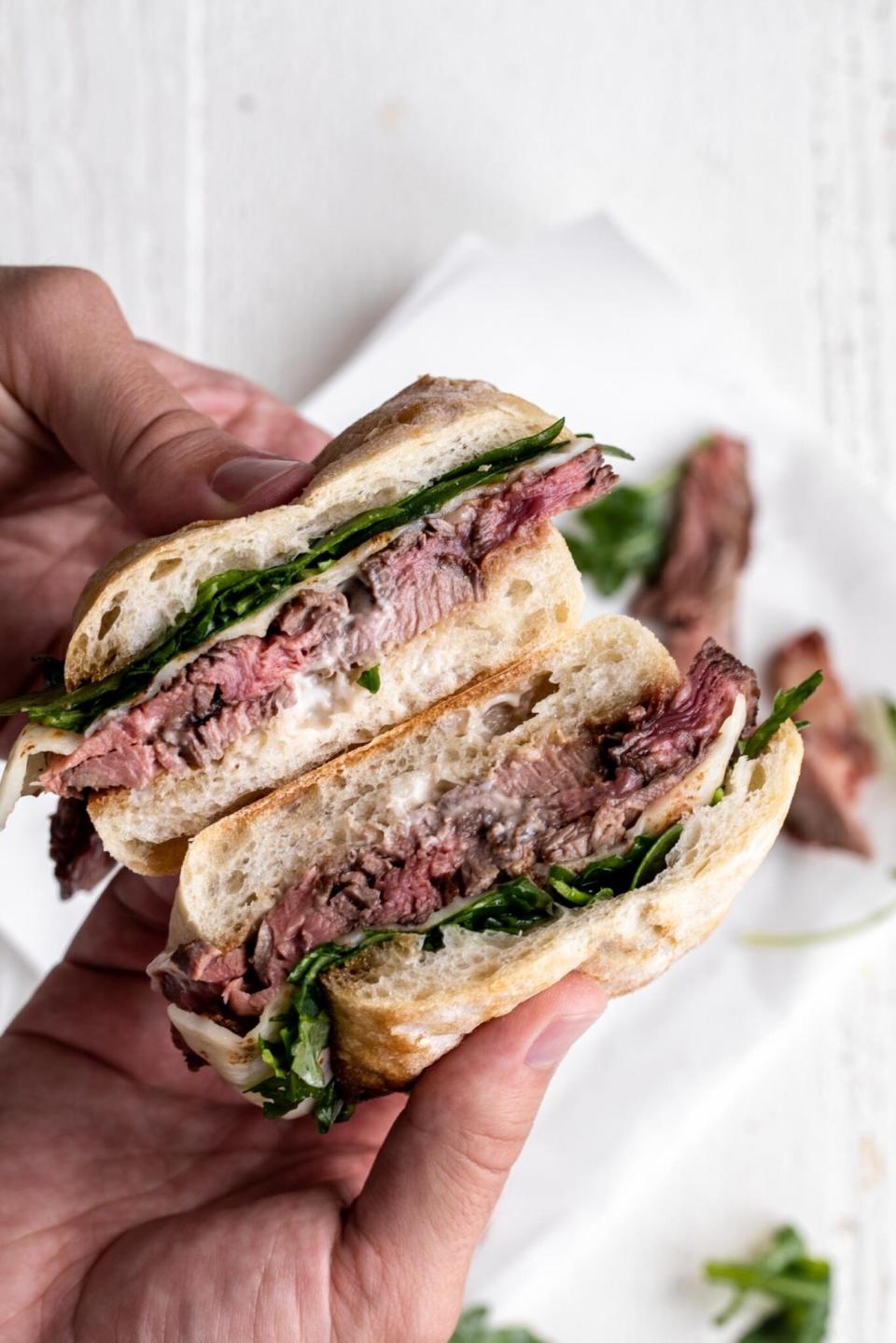 A sliced steak sandwich with horseradish mayo.