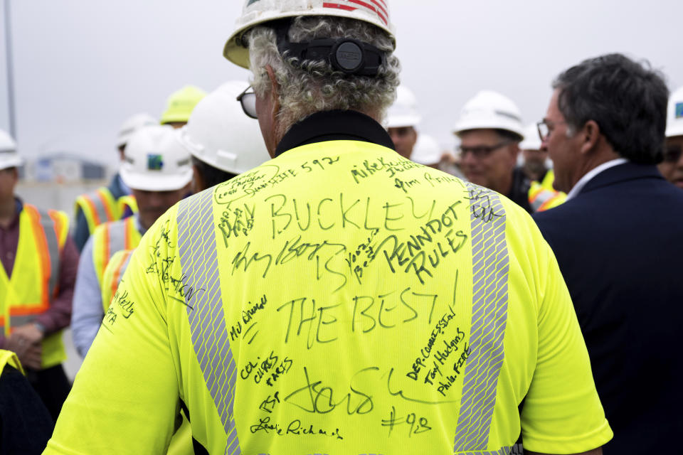 Robert Buckley, president of construction firm Buckley & Co., has his shirt signed during a news conference to announce the reopening of Interstate 95 Friday, June 23, 2023 in Philadelphia. Workers put the finishing touches on an interim six-lane roadway that will serve motorists during construction of a permanent bridge. (AP Photo/Joe Lamberti)