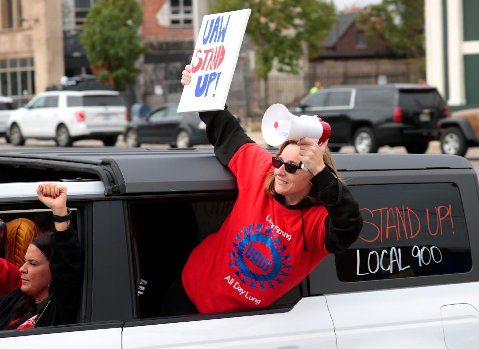 With Malak Jomaa, of Dearborn, left, driving, Amanda Robbins, 38, of Romulus, leans out of a Ford Bronco as a caravan of SUVs heads down Van Dyke and into the entrance of the UAW Solidarity House on Jefferson Avenue in Detroit on Friday, Sept. 29, 2023 for a rally. Both friends work the frame line at the Ford Michigan Assembly plant in Wayne and came to the rally to hear UAW President Shawn Fain speak to the crowd of strikers at the parking lot of the headquarters.