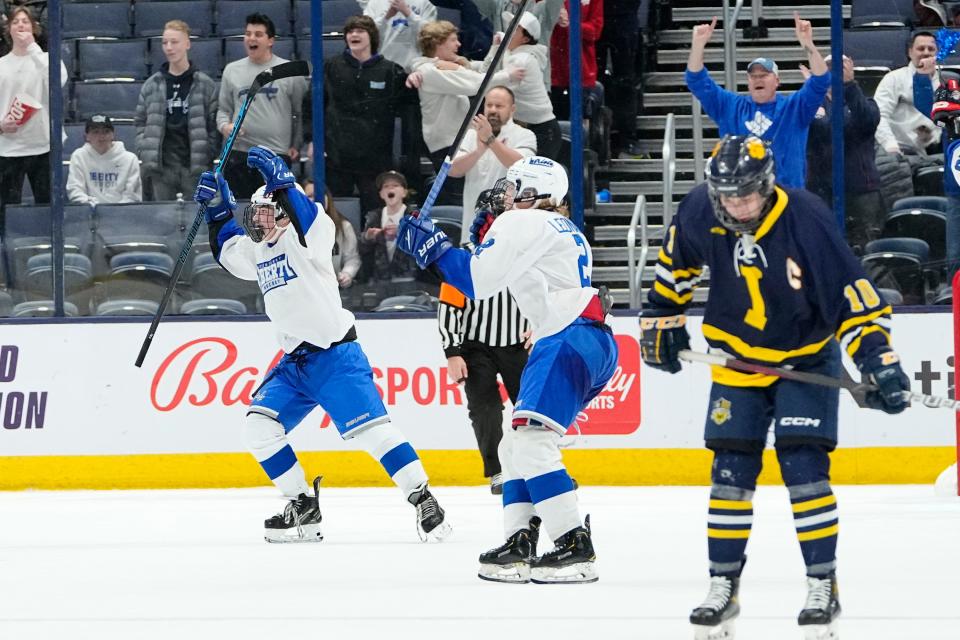 Mar 11, 2023; Columbus, Ohio, USA;  Olentangy Liberty defenseman Carson Reynolds (4) and forward Andrew Leonard (2) celebrate their 4-3 win over Cleveland St. Ignatius in the OHSAA state hockey semifinal at Nationwide Arena. Mandatory Credit: Adam Cairns-The Columbus Dispatch