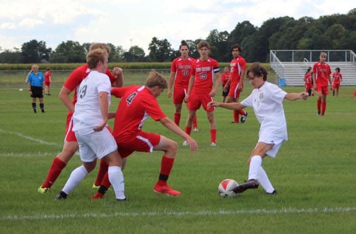 Chaz Harrington (right) and Mason Vanisacker of St. Mary Catholic Central battle for the ball with Milan's Braeden Gotts last season.