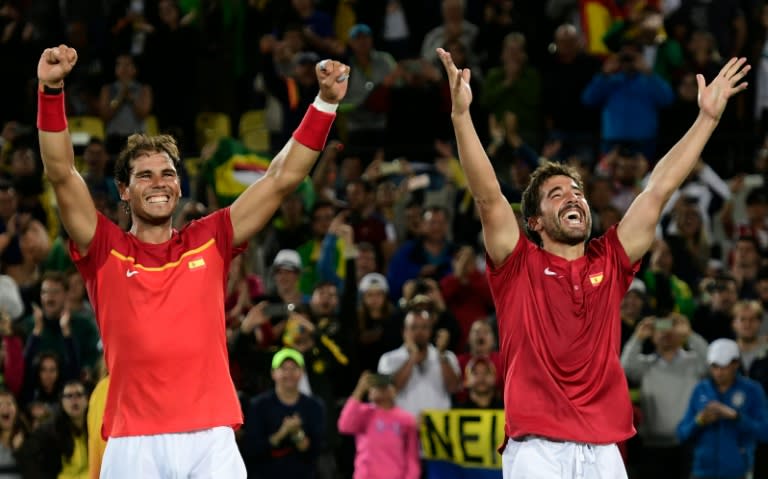 Spain's Rafael Nadal (L) and Marc Lopez celebrate after winning their men's doubles final match against Romania's Florin Mergea and Horia Tecau, during the Rio 2016 Olympic Games, on August 12, 2016