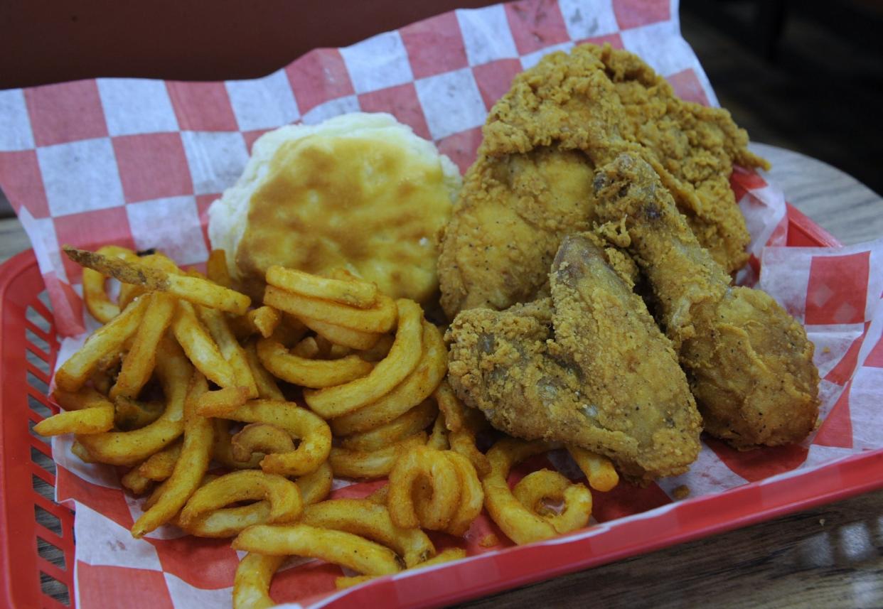 Fried chicken is served with curly fries and a biscuit at The Chicken Stop on Saturday, April 6, 2024.