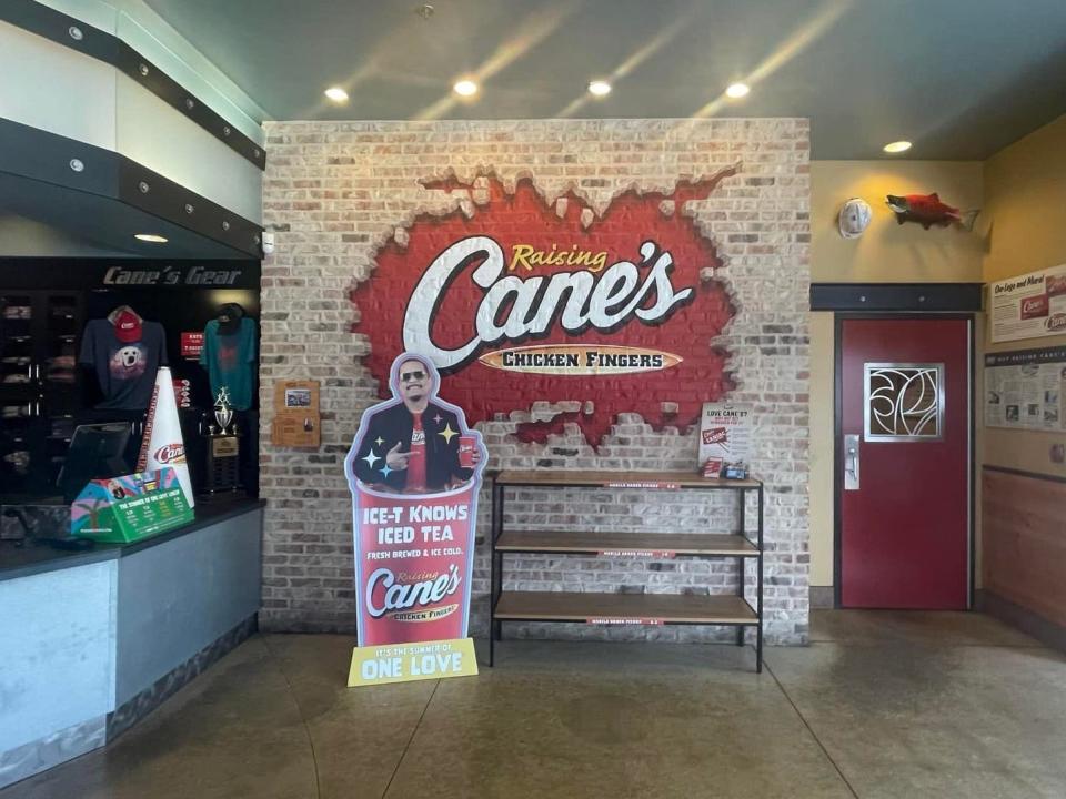 Interior of Raising Cane's with a cutout of Ice-T by register