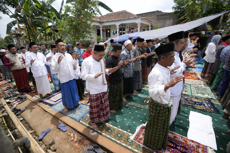 Muslim men perform a Friday prayer outside a mosque badly damaged in Monday's earthquake in Gasol village, Cianjur, West Java, Indonesia, Friday, Nov. 25, 2022. The quake on Monday killed hundreds of people, many of them children and injured thousands. (AP Photo/Achmad Ibrahim)