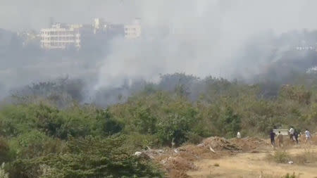 People run to the area of a crashed Indian Air Force Mirage 2000 trainer aircraft in Bengaluru, India, February 1, 2019 in this still taken from social media video. Ramya Pradhan via REUTERS