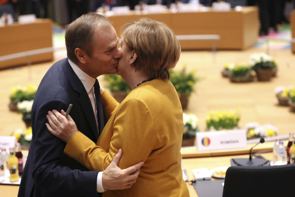 European Council President Donald Tusk, left, greets German Chancellor Angela Merkel during a round table meeting at an EU summit in Brussels, Friday, March 22, 2019. European Union leaders gathered again Friday after deciding that the political crisis in Britain over Brexit poses too great a threat and that action is needed to protect the smooth running of the world's biggest trading bloc. (AP Photo/Francisco Seco)