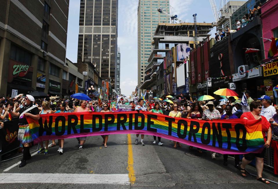 Revellers hold a banner as they participate in the" WorldPride" gay pride Parade in Toronto