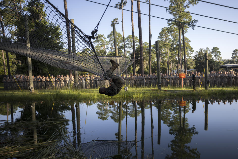 A U.S. Marine Corps recruit demonstrates to a group of recruits how to exit a safety net after failing an obstacle during training at the Marine Corps Recruit Depot, Wednesday, June 28, 2023, in Parris Island, S.C. (AP Photo/Stephen B. Morton)