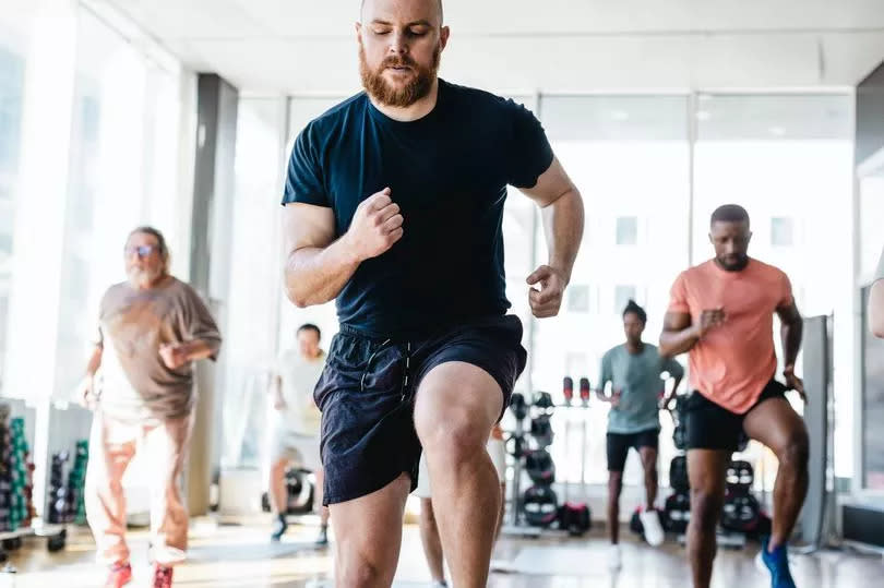 A man exercising with a group indoors
